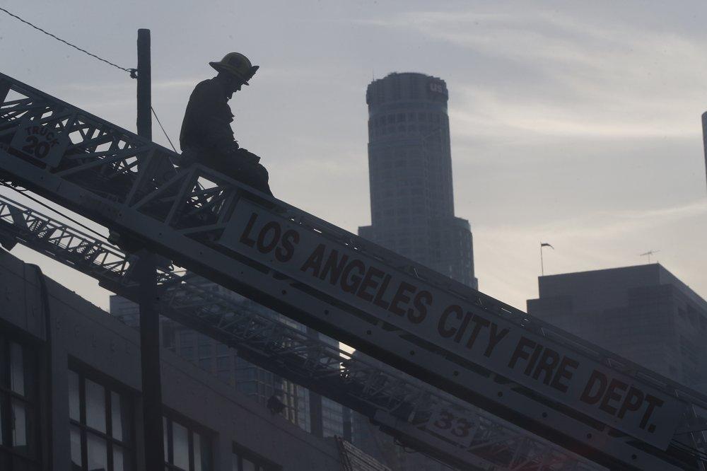 A Los Angeles Fire Department firefighter works the scene of a structure fire that injured multiple firefighters in Los Angeles, Calif., on May 16, 2020. (Damian Dovarganes/AP Photo)