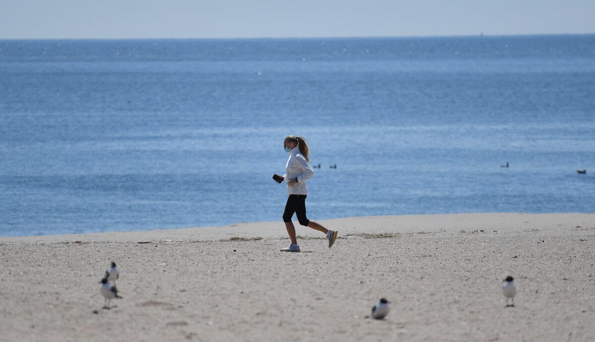 A woman jogs on an empty beach near Coney Island in New York City on April 15, 2020. (Angela Weiss/AFP via Getty Images)