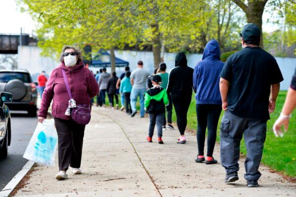People line up to get their care kits containing many hard to find items including masks, sanitizing supplies, personal care items, and education materials at Lynn Technical High School in Lynn, Mass., on May 16, 2020. (Joseph Prezioso/AFP via Getty Images)