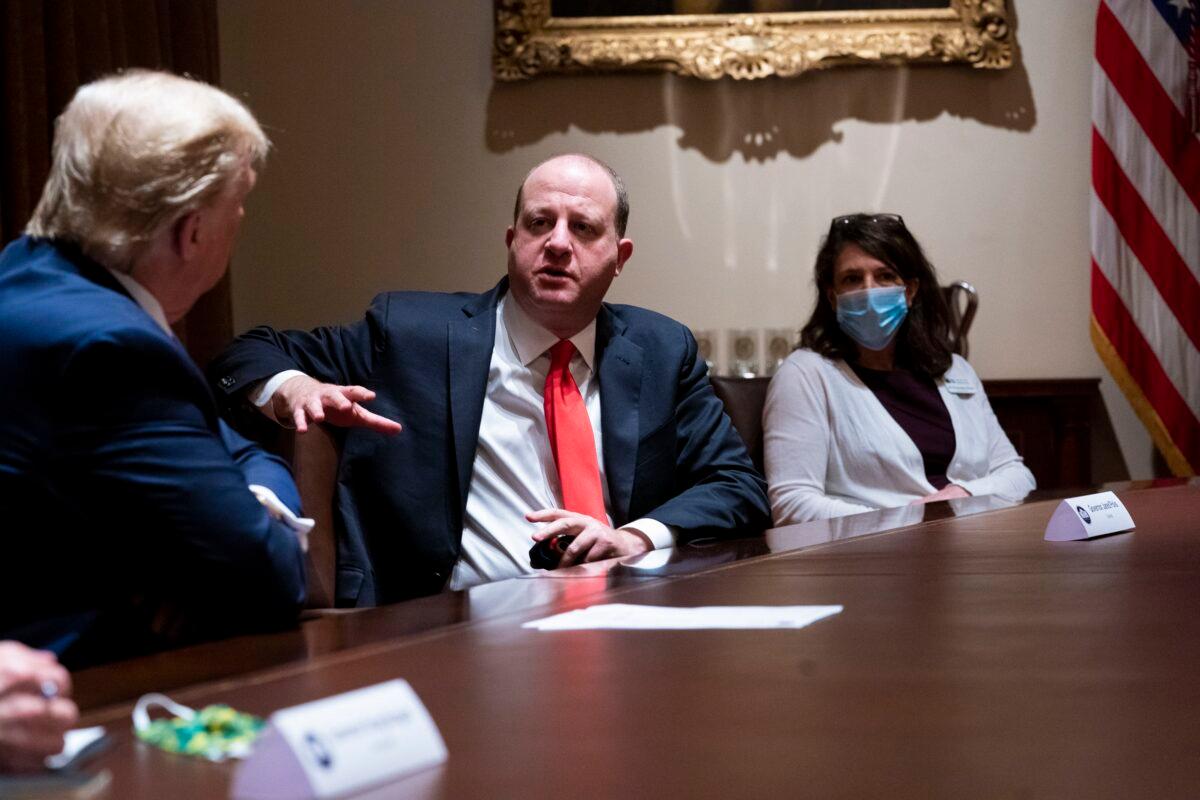 Colorado Governor Jared Polis, center, talks with President Donald Trump during a meeting in the Cabinet Room of the White House in Washington on May 13, 2020. (Doug Mills/Pool/Getty Images)