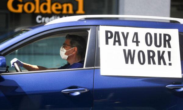 A driver wears a face mask and gloves during a caravan protest calling for California to enforce the AB5 law, in Los Angeles on April 16, 2020. (Mario Tama/Getty Images)