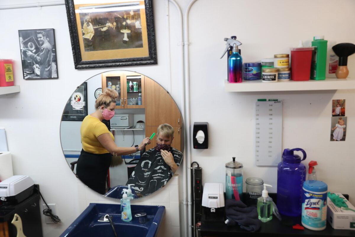 Katie Toczak cuts the hair of Ben Marquette at the Las Olas Barbershop after it opened in Fort Lauderdale, Fla. on May 18, 2020. (Joe Raedle/Getty Images)