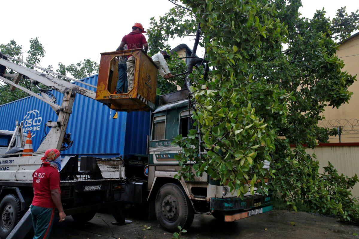 Rescue workers cut fallen tree branches after heavy winds caused by Cyclone Amphan, in Kolkata, India, on May 20, 2020. (Rupak De Chowdhuri/Reuters)