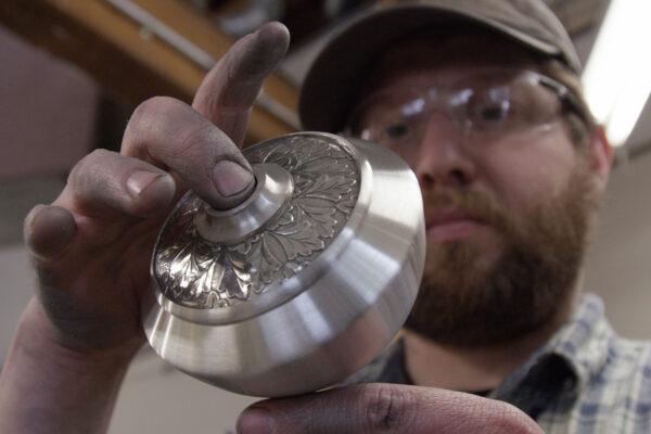  Danforth Pewter worker Jake Michaud inspects a handspun pewter oil lamp base. (Danforth Pewter)