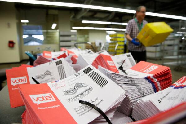 Empty envelopes of opened vote-by-mail ballots for the presidential primary are stacked on a table at King County Elections in Renton, Washington, on March 10, 2020. (Jason Redmond/AFP via Getty Images)