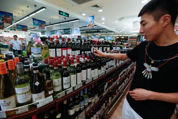 A customer selects a bottle of Australian wine at a supermarket on June 17, 2015 in Beijing, China. (Lintao Zhang/Getty Images)