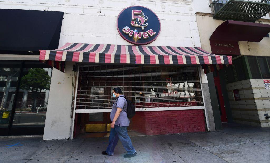 A pedestrian wears his face mask while walking past a closed Nickel Diner in Los Angeles, Calif., on May 7, 2020. (Frederic J. Brown/AFP/Getty Images)