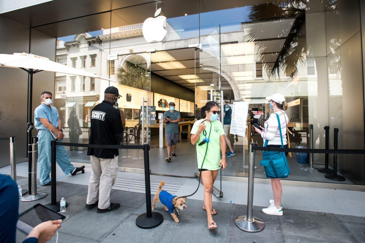 A customer exits the Apple Store in Charleston, S.C. on May 13, 2020. Customers had their temperatures taken and were required to wear masks at the South Carolina store, as locations in Idaho, Alabama, and Alaska reopened as well following forced closures due to the CCP virus. (Sean Rayford/Getty Images)