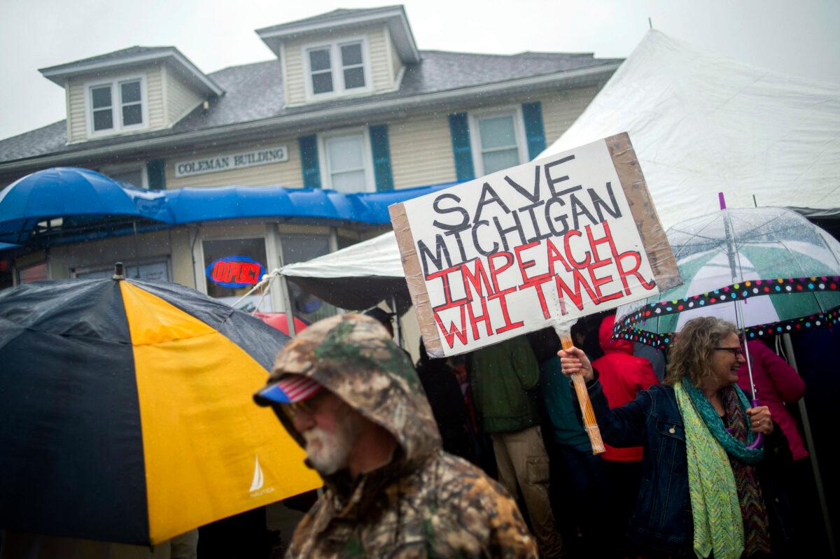 Michigan residents gather in protest of Gov. Gretchen Whitmer before a news conference outside of Karl Manke's Barber and Beauty in Owosso, Mich. on May 18, 2020. (Jake May/The Flint Journal via AP)