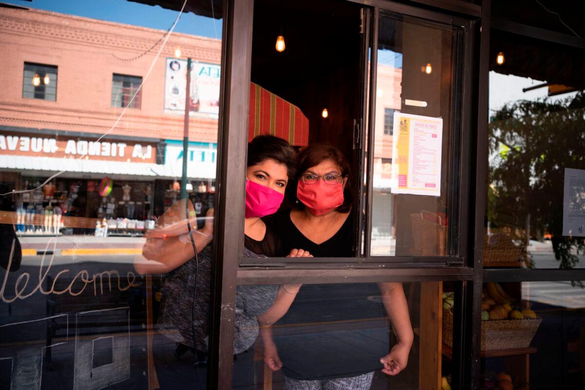 Vanessa Zubia-Meza and her mother Margie Zubia are pictured in the window of their new restaurant called El Paseo in downtown El Paso, Texas on May 18, 2020. (Paul Ratje/AFP via Getty Images)