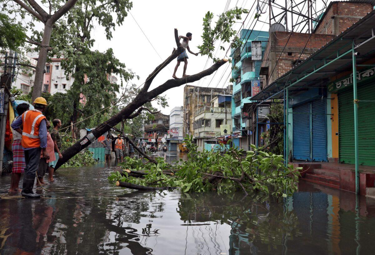 A man cuts branches of an uprooted tree after Cyclone Amphan made its landfall, in Kolkata, India, on May 21, 2020. (Rupak De Chowdhuri/TPX Images of the day/Reuters)