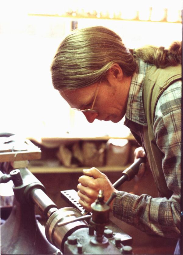 Fred Danforth uses a metal tool to hand spin some pewter. (Danforth Pewter)