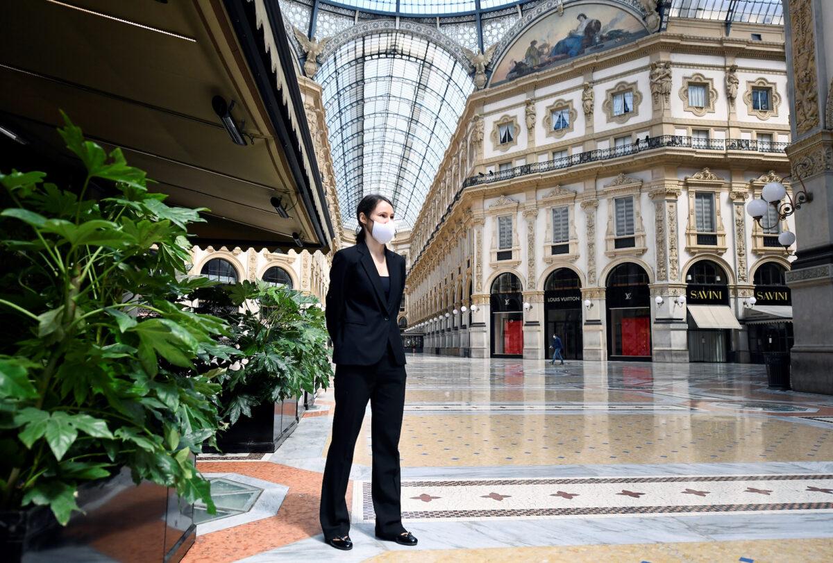 A restaurant employee stands at the Galleria Vittorio Emanuele II as Italy begins a staged end to a nationwide lockdown in Milan, Italy, on May 4, 2020. (Flavio Lo Scalzo/Reuters)