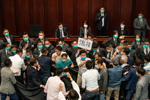 Pro-democracy and pro Beijing lawmakers scuffle at the House Committee's election of chairpersons, presided by pro-Beijing lawmaker Chan Kin Por at the Legislative Council in Hong Kong, on May 18, 2020. (Anthony Kwan/Getty Images)