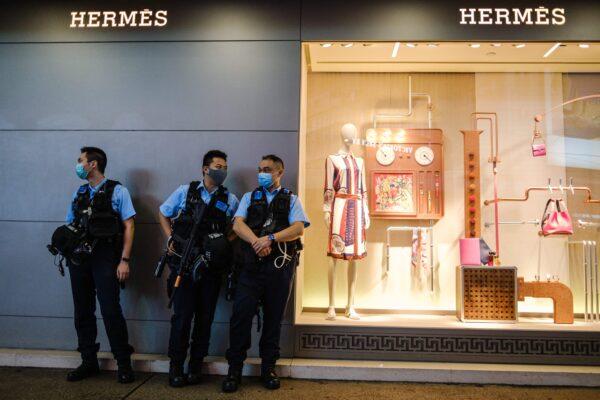 Police stand guard outside a high-end fashion store in Hong Kong on May 21, 2020. (Anthony Wallace/AFP via Getty Images)