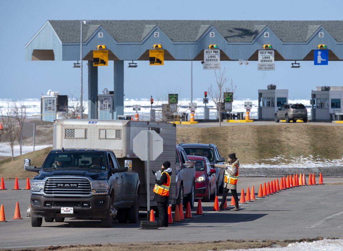 Provincial health department workers stop traffic that has crossed the Confederation Bridge in Borden-Carleton, P.E.I., on March 22, 2020. (The Canadian Press/Andrew Vaughan)