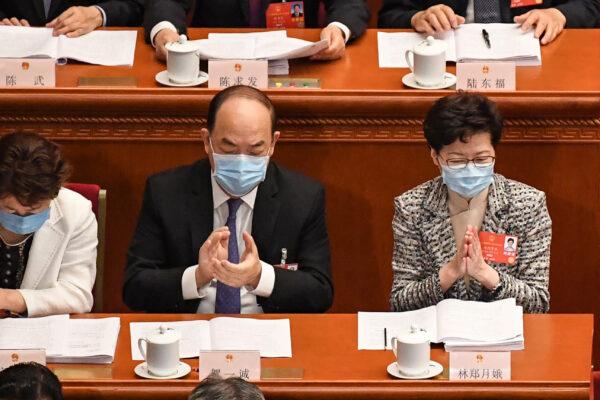 Hong Kong Chief Executive Carrie Lam (R) and Macau Chief Executive Ho Iat Seng (C) attend the opening session of the National People's Congress (NPC) at the Great Hall of the People in Beijing on May 22, 2020. (LEO RAMIREZ/AFP via Getty Images)