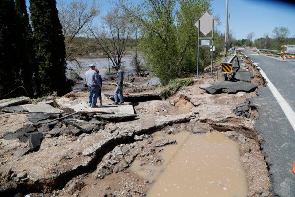 Bob Yahrmarkt (R) stands on his washed out driveway next to his home, in Edenville, Mich., on May 20, 2020. (Carlos Osorio/AP Photo)