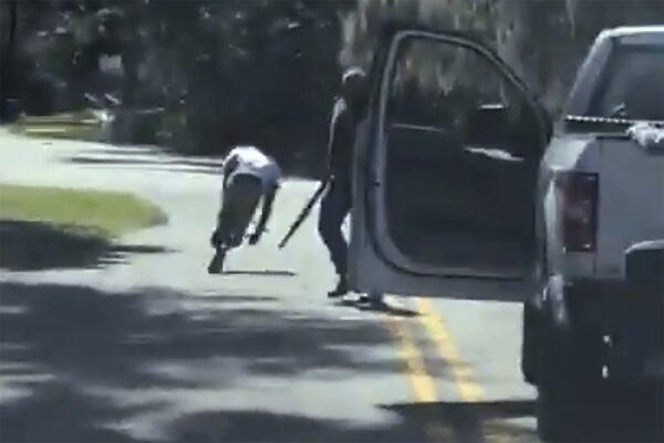 This image from video posted on Twitter on May 5, 2020, purports to show Ahmaud Arbery stumbling and falling to the ground after being shot as Travis McMichael stands by holding a shotgun in a neighborhood outside Brunswick, Ga., on Feb. 23, 2020. (Twitter via AP)