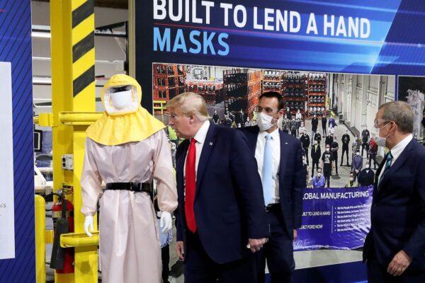 President Donald Trump looks at a display of protective wear while touring the Ford Rawsonville Components Plant, which is making ventilators and medical supplies, during the CCP virus pandemic in Ypsilanti, Michigan, on May 21, 2020. (Leah Millis/Reuters)