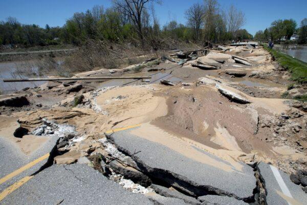 Chunks of asphalt rest broken apart after flood waters decimated the bridge in downtown Sanford, Mich., on May 21, 2020. (Jake May/MLive.com/The Flint Journal via AP)