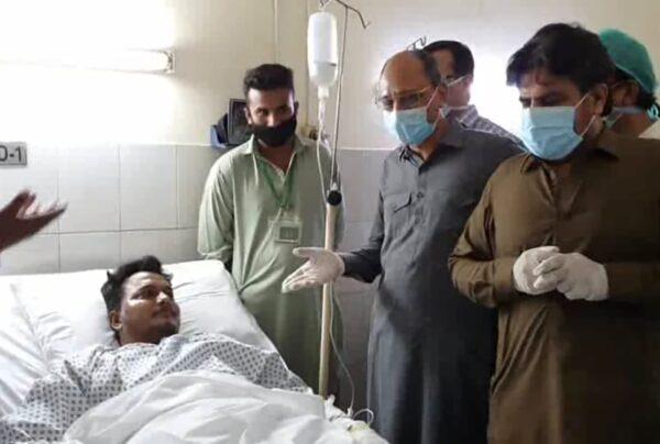Pakistani provincial minister Saeed Ghani, second from right, meets Mohammad Zubair who survived a plane crash, at a hospital in Karachi, Pakistan, on May 22, 2020. (Sind Press Information Department/AP)