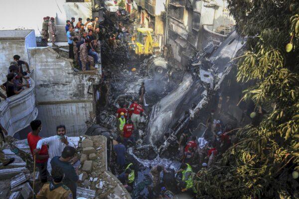 Volunteers look for survivors of a plane that crashed in a residential area of Karachi, Pakistan on May 22, 2020. (Fareed Khan/AP Photo)