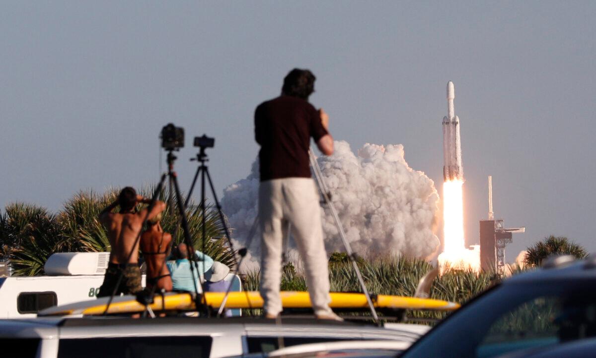 Visitors at Playalinda Beach look on as a SpaceX Falcon Heavy rocket launches from Pad 39B at the Kennedy Space Center in Florida, on April 11, 2019. (Gregg Newton/AFP via Getty Images)