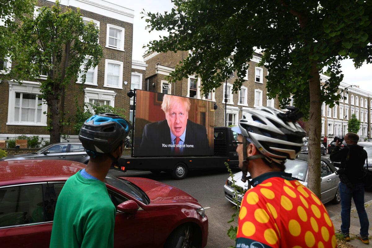 Political campaign group Led By Donkeys transport a screen showing a prerecorded video link of Britain's Boris Johnson delivering a statement, outside the home of his senior aide Dominic Cummings, in London, UK, on May 24, 2020. (Victoria Jones/PA via AP)