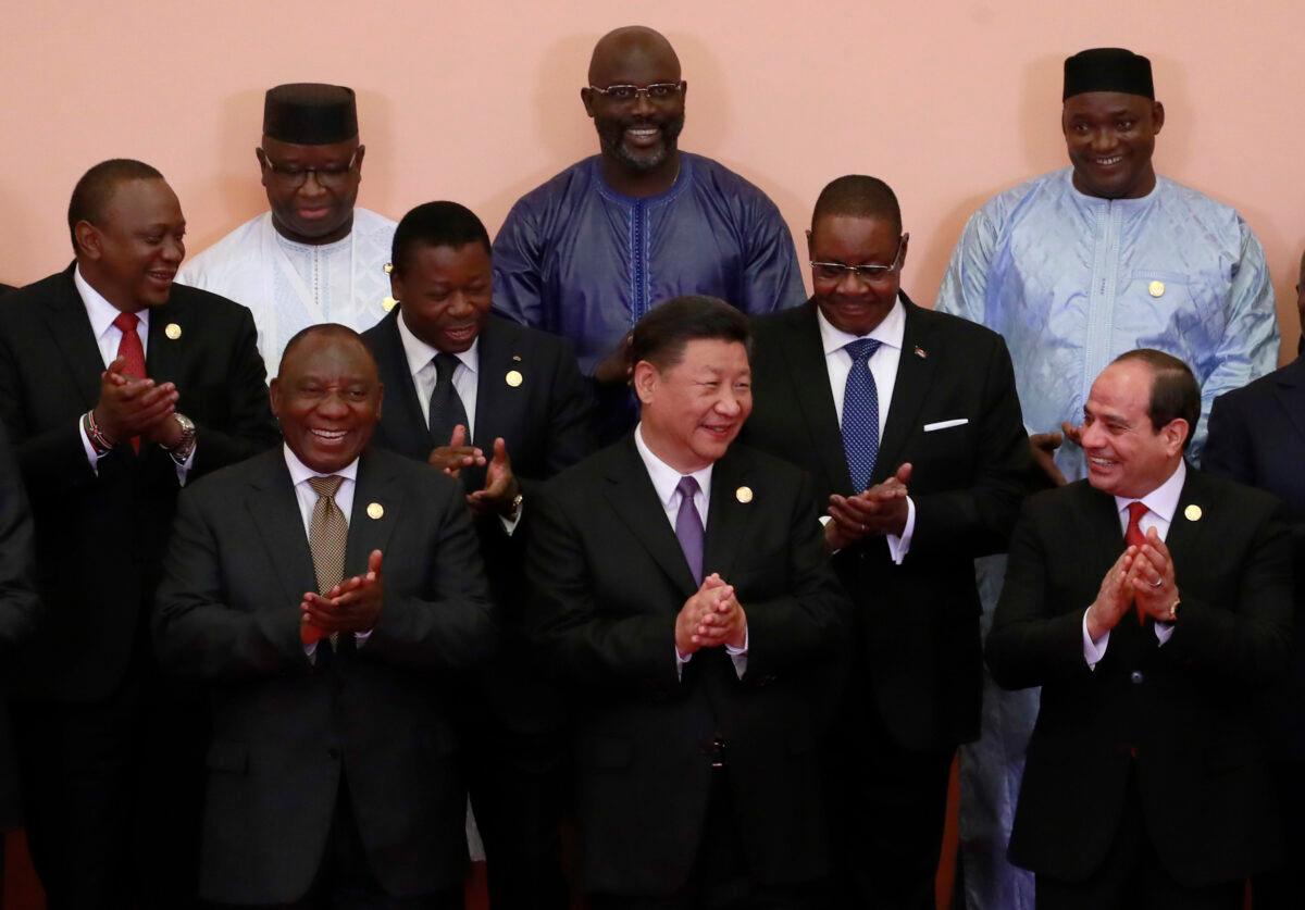 Chinese Communist Party leader Xi Jinping (front C), South African President Cyril Ramaphosa (front 3-L), Egyptian President Abdel Fattah al-Sisi (front L), Kenya’s President Uhuru Kenyatta (2nd row L), Togo’s President Faure Gnassingbé (2nd row C), Malawi's President Arthur Peter Mutharika (2nd row R), Sierra Leone President Julius Maada Bio (last row L), Liberian President George Weah (last row C) and other African leaders clap during a group photo session during the Forum on China-Africa Cooperation (FOCAC) 2018 Beijing Summit in Beijing on Sept. 3, 2018. (How Hwee Young - Pool/Getty Images)