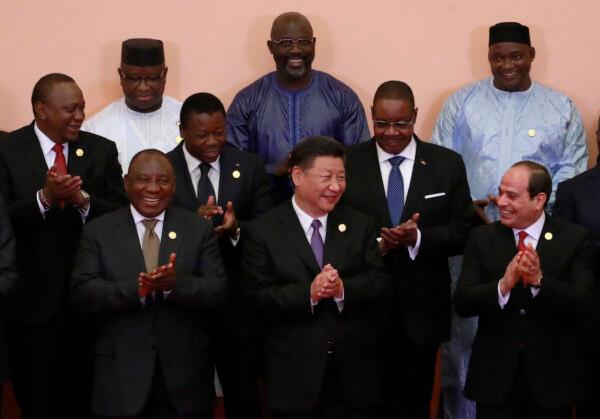 Chinese Communist Party leader Xi Jinping (front C), South African President Cyril Ramaphosa (front L), Egyptian President Abdel Fattah el-Sisi (front R), Kenya’s President Uhuru Kenyatta (2nd row L), Togo’s President Faure Gnassingbé (2nd row C), Malawi's President Arthur Peter Mutharika (2nd row R), Sierra Leone President Julius Maada Bio (last row L), Liberian President George Weah (last row C) and other African leaders clap during a group photo session during the Forum on China-Africa Cooperation (FOCAC) 2018 Beijing Summit in Beijing, China, on Sept. 3, 2018. (How Hwee Young/Pool/Getty Images)