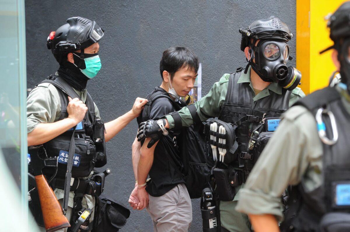 A protester dressed in black is handcuffed by the police at Hennessy Road in Causeway Bay, Hong Kong, on May 24, 2020. (Hong Kong branch of The Epoch Times)