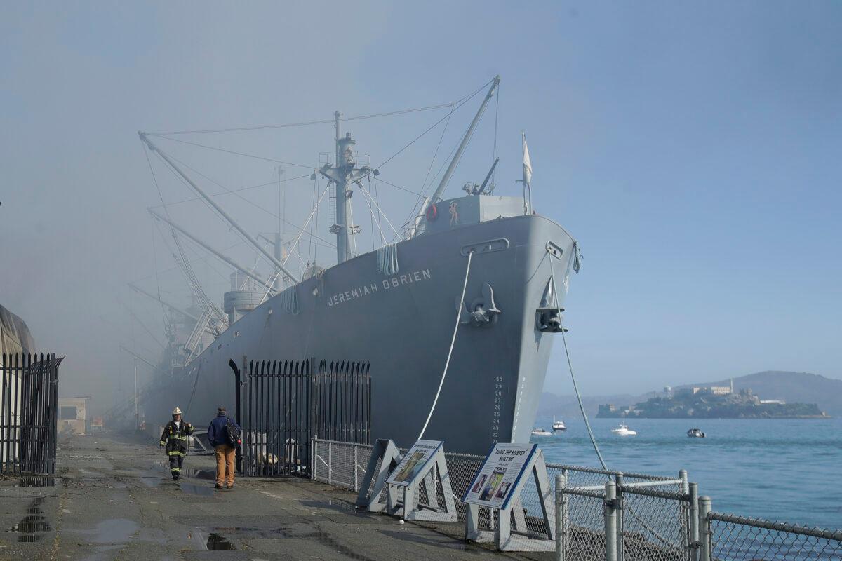 Fire officials work in front of a sign for Musee Mecanique after a fire broke out before dawn at Fisherman's Wharf in San Francisco, Saturday, May 23, 2020. (Jeff Chiu/AP photo)