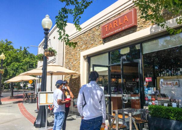 People stop in front of Tarla Mediterranean Bar and Grill in Napa, Calif., on May 23, 2020. (Ilene Eng/The Epoch Times)