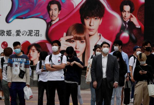 Passersby wearing protective face masks are seen as the spread of the CCP virus continues, at Shibuya crossing in Tokyo, on May 25, 2020. (Issei Kato/Reuters)