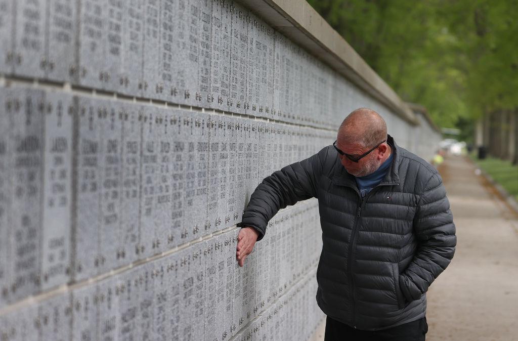 Scott Gauser of Brooklyn, N.Y., pays his respects to former Marine Nielsen Paul, who was his best friend, at Long Island National Cemetery on May 24, 2020 in Farmingdale, N.Y. (Al Bello/Getty Images)