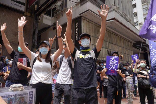 Protesters gesture with five fingers, signifying the "Five demands - not one less" as they march along a downtown street during a pro-democracy protest against Beijing's national security legislation in Hong Kong, on May 24, 2020. (Vincent Yu/AP Photo)