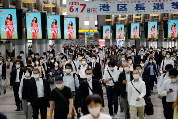 People wearing protective masks walk during rush hour on the first day after the Japanese government lifted the state of emergency in Tokyo, Japan, on May 26, 2020. (Kim Kyung-Hoon/Reuters)