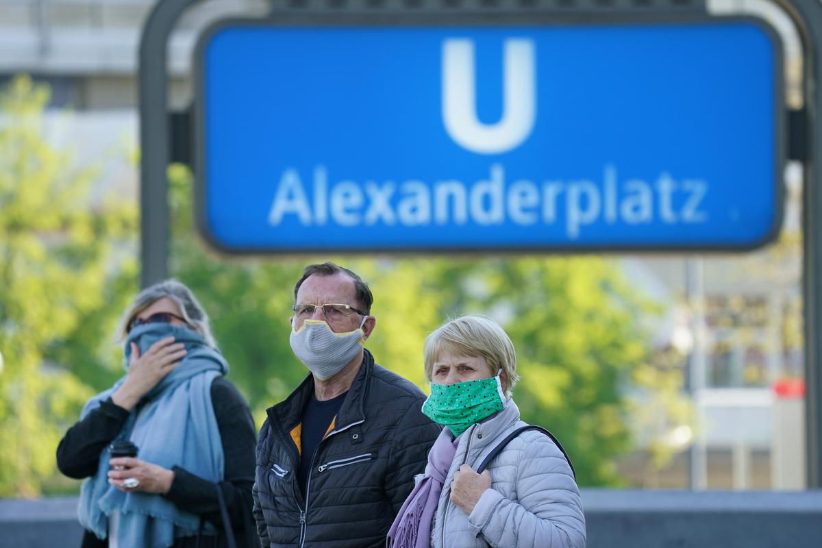 People wearing face masks wait at a tram stop at Alexanderplatz in Berlin, Germany, on April 27, 2020. (Sean Gallup/Getty Images)
