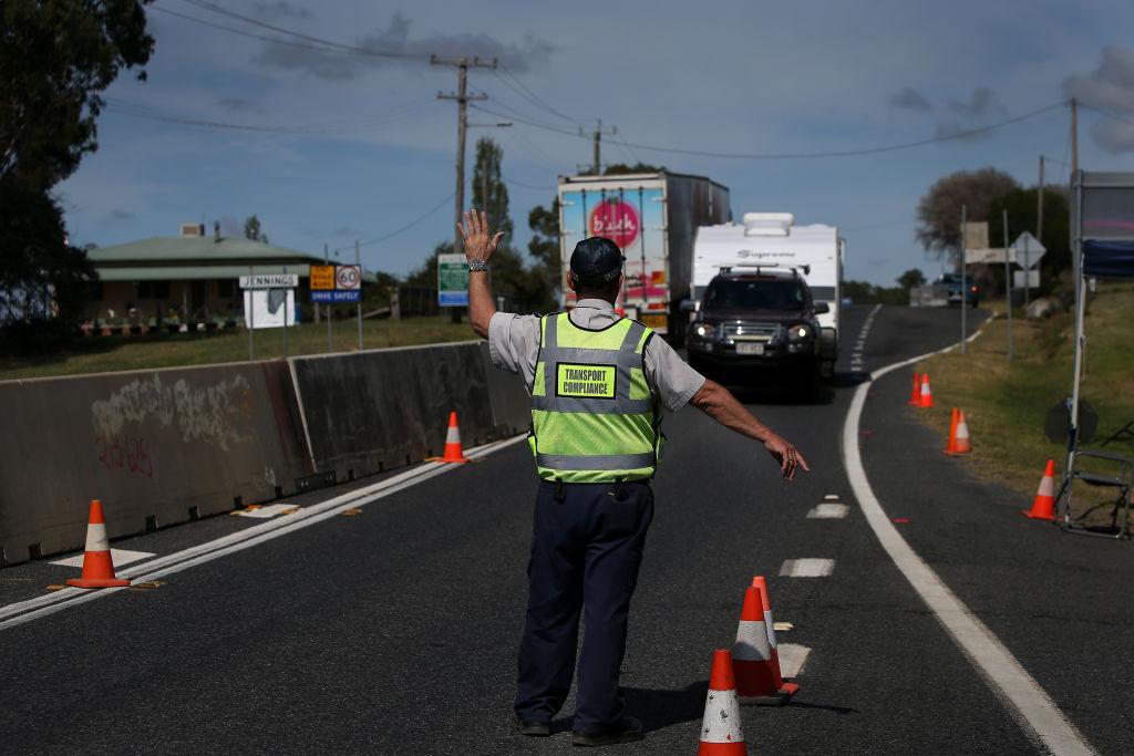 A Queensland Transport Inspector signals to a driver approaching the border in Wallangarra, Australia on April 2. 2020. (Lisa Maree Williams/Getty Images)