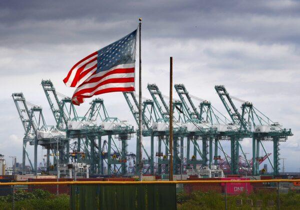 The U.S. flag flies over shipping cranes and containers in Long Beach, Calif., on March 4, 2019. (Mark Ralston/AFP via Getty Images)