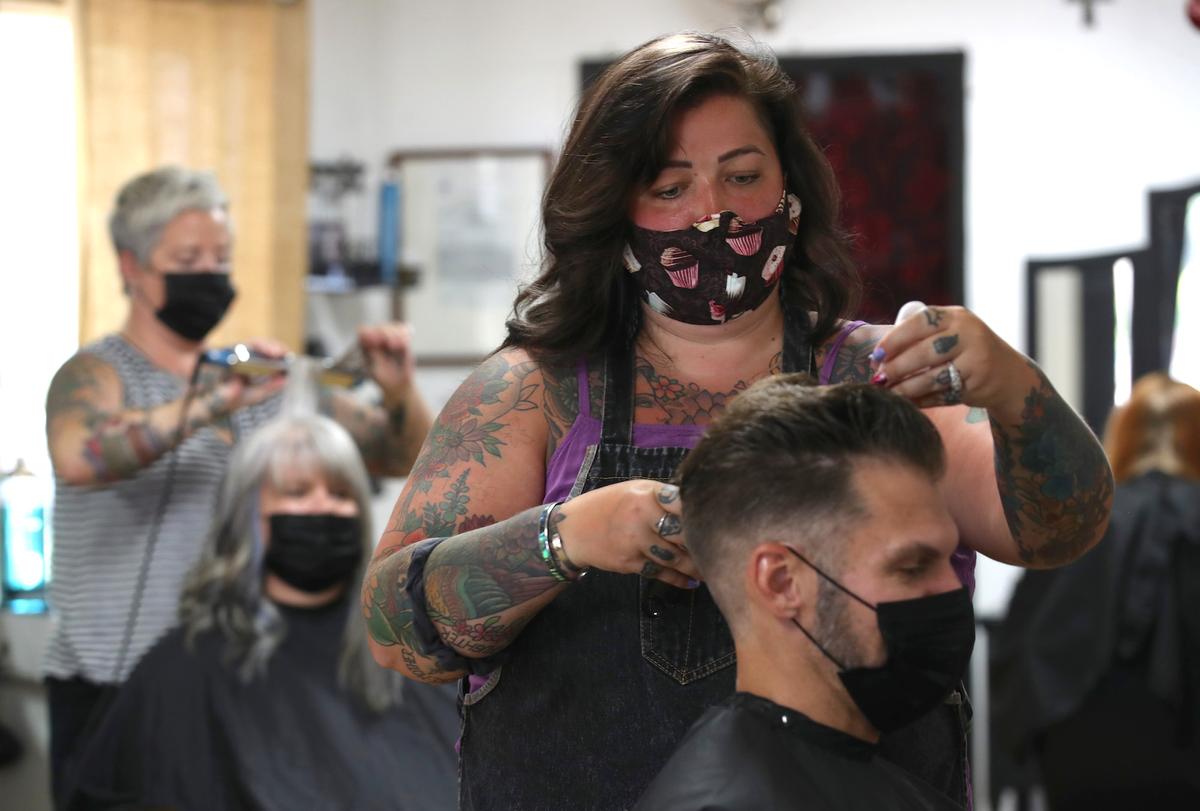 A hair stylist cuts a customer’s hair at The Parlor in Napa, Calif., on May 27, 2020. (Justin Sullivan/Getty Images)