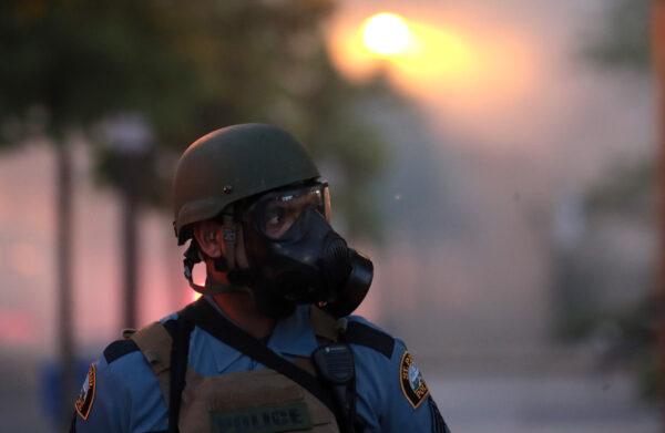 A police officer stands near a cloud of tear gas during a protest in St. Paul, Minnesota, on May 28, 2020. Today marks the third day of ongoing protests after the police killing of George Floyd. Four Minneapolis police officers have been fired over the death. (Scott Olson/Getty Images)