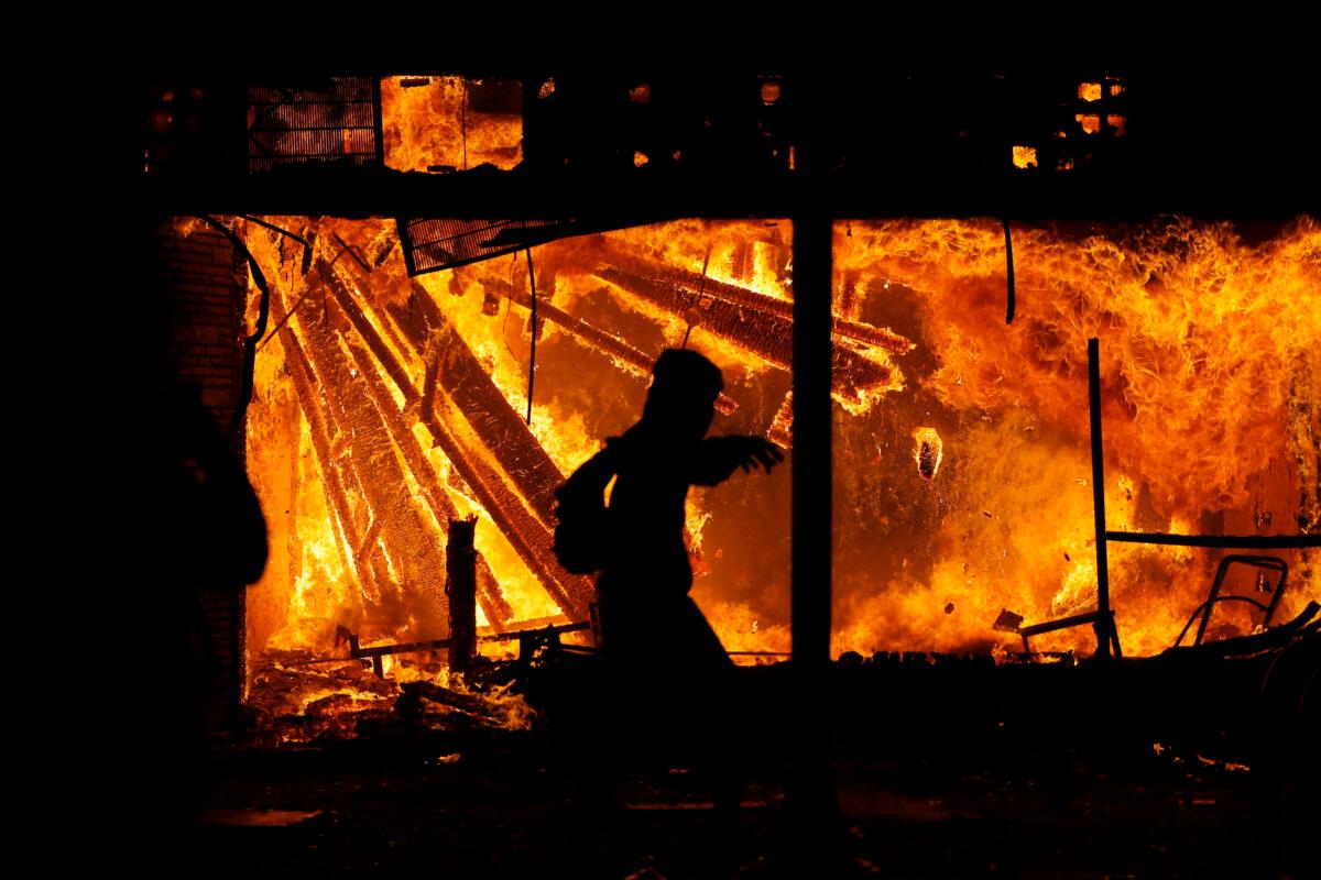 A person in front of the burning 3rd Precinct of the Minneapolis Police Department, on May 28, 2020. (Julio Cortez/AP Photo)