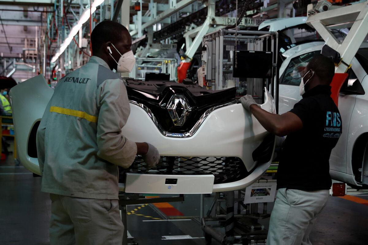 Employees, wearing protective face masks, work on the automobile assembly line of Renault ZOE cars at the Renault automobile factory in Flins as the French carmaker ramps up car production with new security and health measures during the outbreak of the CCP virus in France, on May 6, 2020. (Gonzalo Fuentes/File Photo/Reuters)