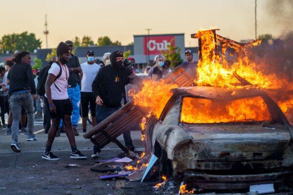 Protesters throw objects onto a burning car outside a Target store near the Third Police Precinct in Minneapolis, Minnesota, on May 28, 2020. (Kerem Yucel/AFP via Getty Images)