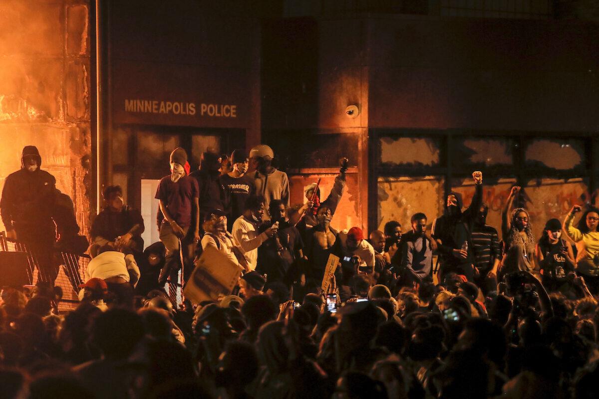 Protesters gather around after setting fire to the entrance of a police station as demonstrations continue in Minneapolis, Minnesota, on May 28, 2020. (Carlos Barria/Reuters)