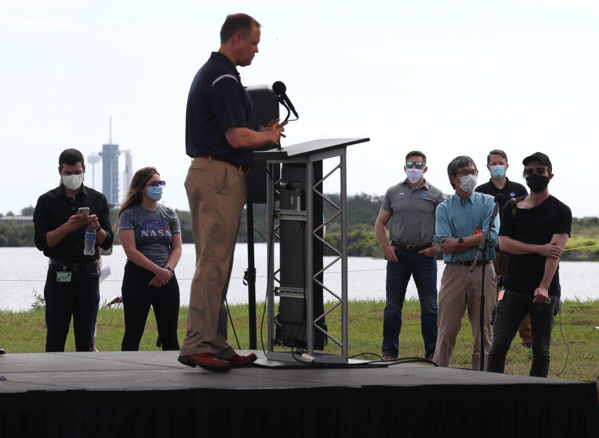 Reporters wearing masks listen as NASA Administrator Jim Bridenstine speaks to them at the Kennedy Space Center in Cape Canaveral, Fla. on May 29, 2020. (Joe Raedle/Getty Images)