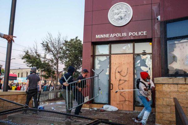 Protesters use a barricade to try and break the windows of the Third Police Precinct in Minneapolis, Minnesota, on May 28, 2020. (Kerem Yucel/AFP via Getty Images)