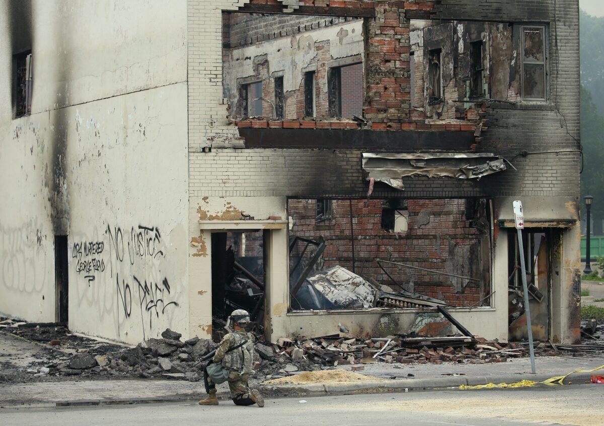 A member of the National Guard patrols near a burned-out building on the fourth day of protests in Minneapolis, Minn., on May 29, 2020. (Scott Olson/Getty Images)